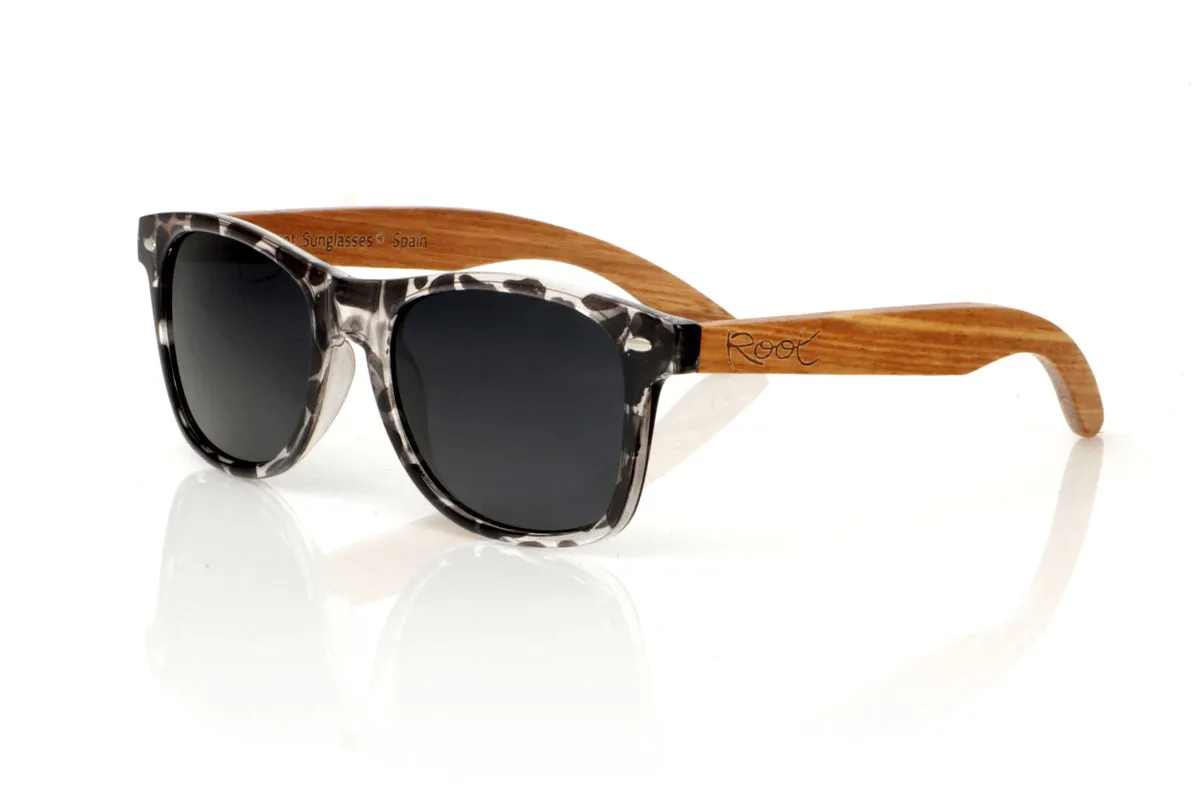 Wood eyewear of Walnut KHUN. KHUN are the new must-have for sunglasses lovers. With its design inspired by the classics, these glasses feature a transparent Tortoiseshell frame in a palette of gray and black with a satin gloss finish, bringing a modern mix to an iconic style. The Walnut temples not only contrast beautifully with the frame, but also add a touch of warmth and naturalness. Perfect for any occasion, the KHUN offers clear vision and protection without compromising style. With measurements of 152x49 and a caliber of 54, they fit perfectly, promising comfort and an impeccable look to those who wear them. for Wholesale & Retail | Root Sunglasses® 